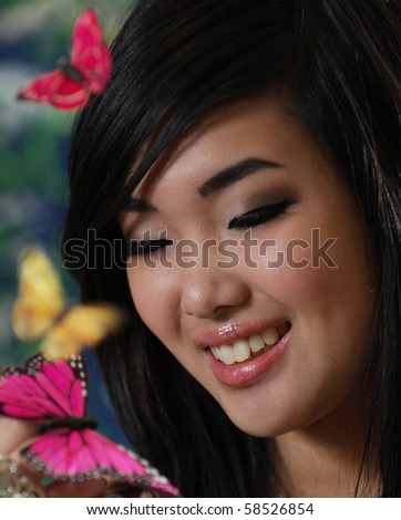 A beautiful Korean girl with butterflies landing on her hand