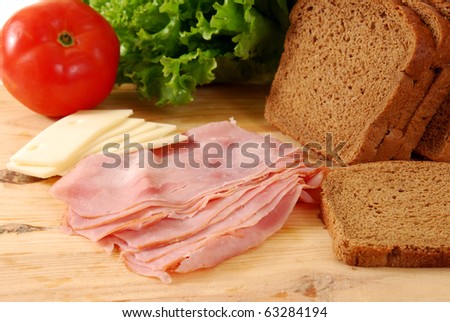 Ingredients to make a ham sandwich laid out on a cutting board