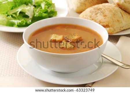 A bowl of vegetable beef soup with croutons