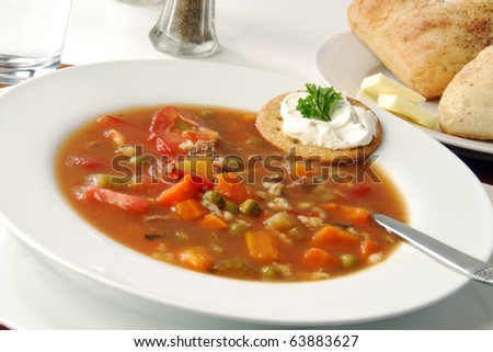 A bowl of soup and rolls