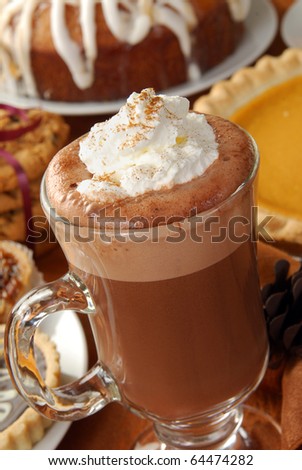 A cappuccino topped with whipped cream and cinnamon on a dessert table