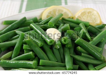 A bowl of hot green beans with melted butter