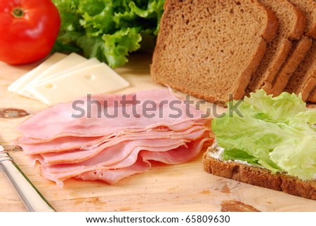 Thin sliced deli ham being made into a sandwich