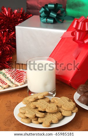 A plate of ginger bread men cookies with milk and Christmas presents