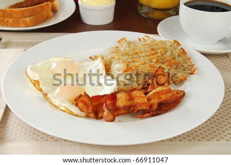 Breakfast with bacon, eggs, hash browns, toast and coffee