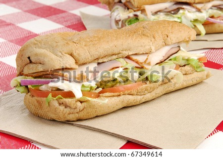 A sub sandwich with ham, beef, turkey and cheese