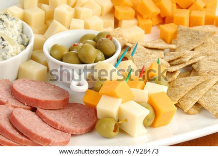 A party tray loaded with cheeses, meats, dips, olives and crackers