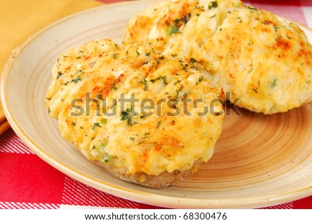 A plate with twice baked potatoes topped with cheese, parsley and chives