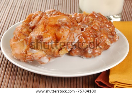 A plate of apple fritters and a glass of milk