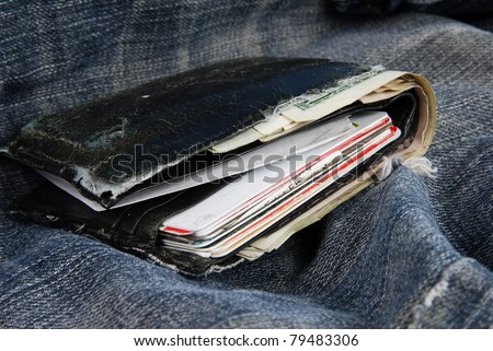 A old worn wallet on a pair of faded blue jeans
