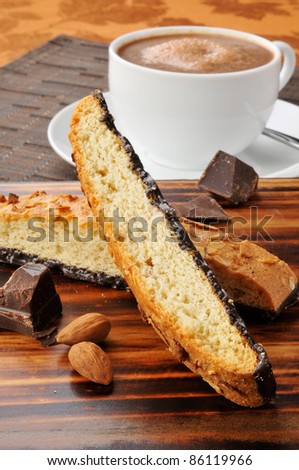 Almond chocolate biscotti with a cup of hot chocolate in the background