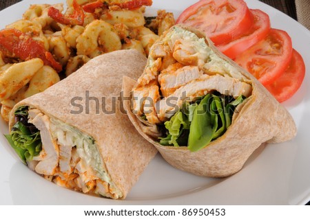 A plate of barbecued chicken wraps with sliced tomatoes and tortellini