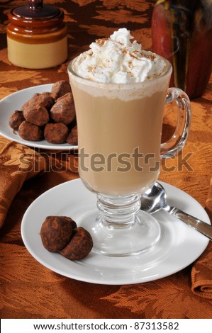 A cup of cappuccino with whipped cream and truffles