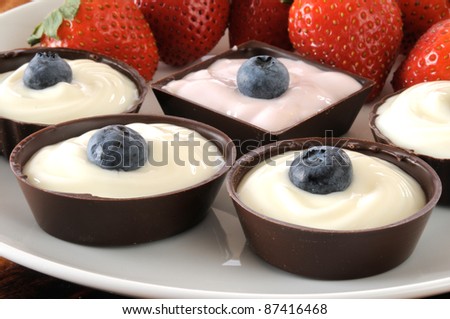Chocolate dessert cups filled with yogurt and served with strawberries