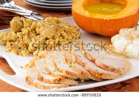 Turkey, dressing, mashed potatoes and pumpkin soup served family style for a holiday dinner