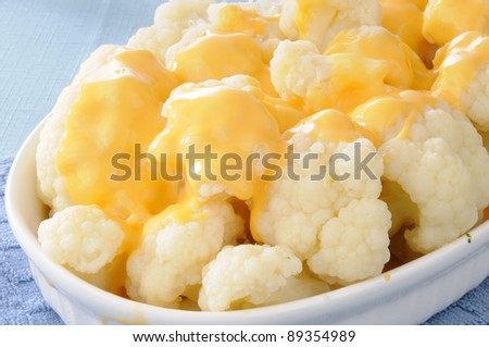 A casserole dish of steamed cauliflower and cheese sauce