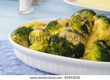 A dish of steamed broccoli and cheese sauce