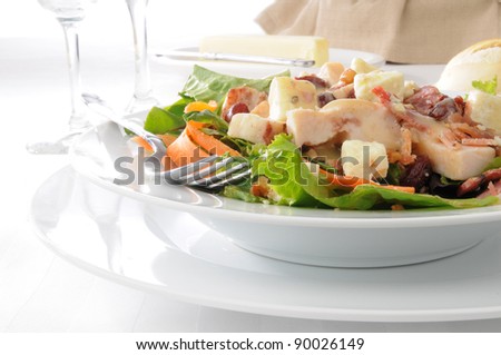 A salad with blue cheese, chicken, bacon, walnuts and dried cherries