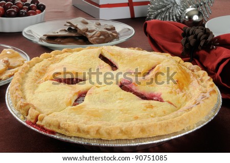 A fresh baked cherry pie with peanut brittle, chocolates and Christmas decorations