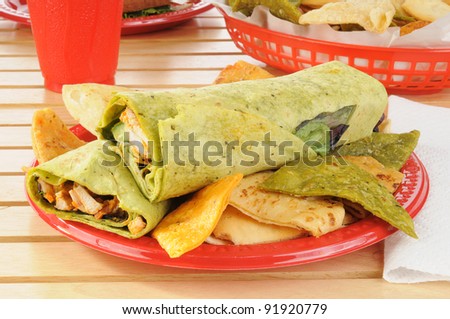 A chicken wrap sandwich with fried vegetable tortilla chips