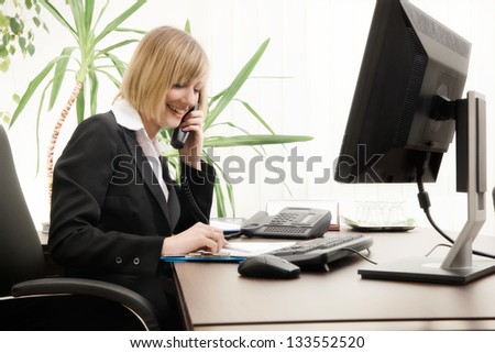 Female executive talking on phone in office