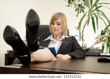 Businesswoman sitting with feet up on desk. Focus on face