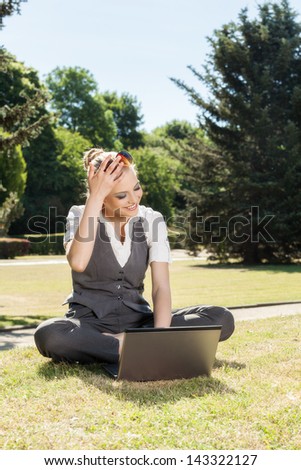 Young woman with laptop in the park
