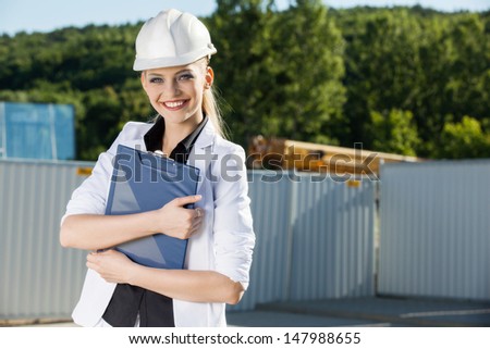 Female engineer against building yard