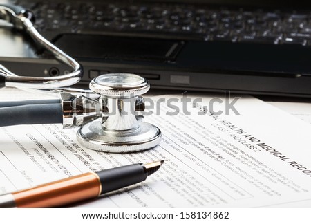 Medical form, stethoscope, laptop and pen