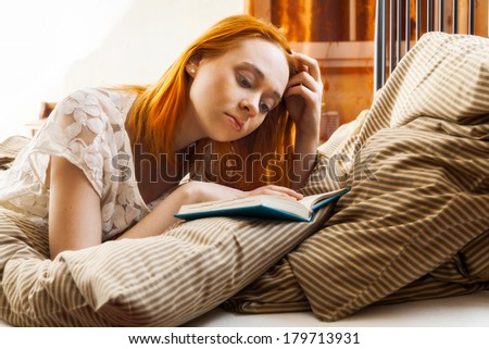 Woman writing diary or studying in bed thinking