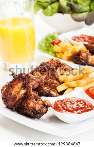 Chicken wings with fries french and spicy sauce on a plate