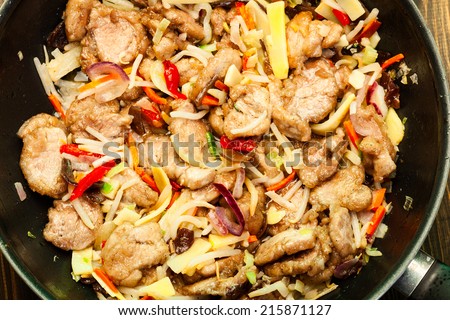 Pork in chinese with vegetables in a wok pan