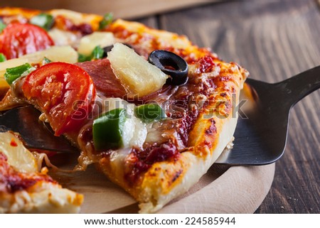 Fresh baked pizza hawaii on cutting board