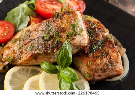 Fried salmon steak with vegetables and lemon