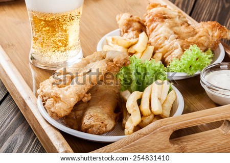 Traditional fish and chips with tartar sauce on a tray