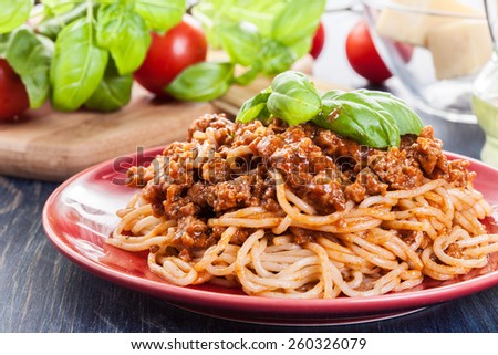Spaghetti bolognese with cheese and basil on a plate