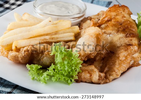 Traditional fish and chips with tartar sauce on a plate