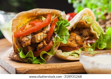 Doner kebab - fried chicken meat with vegetables in pita bread