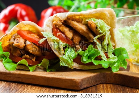 Doner kebab - fried chicken meat with vegetables in pita bread