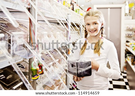 a young girl in a sweet shop, all logos removed