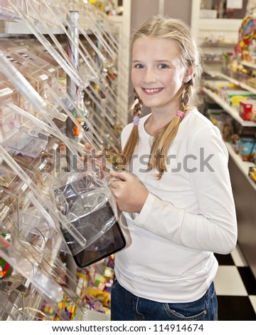 a young girl in a sweet shop, smile to camera, all logos removed