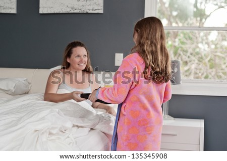 mum smiles as she receives breakfast in bed for mother's day