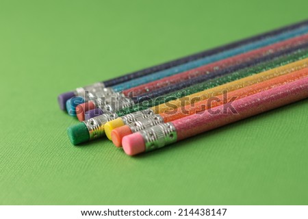 lead pencils, brightly colored on a green background