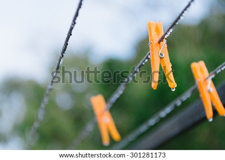 orange pegs on clothesline in the rain, it\'s a dryer day
