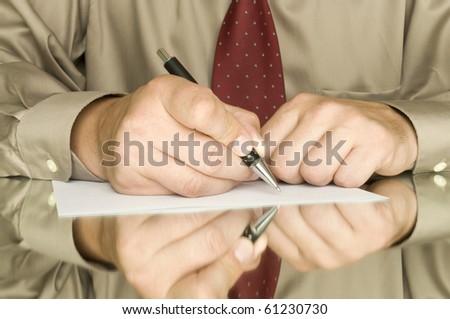 hands with pen writing on the white page and reflection