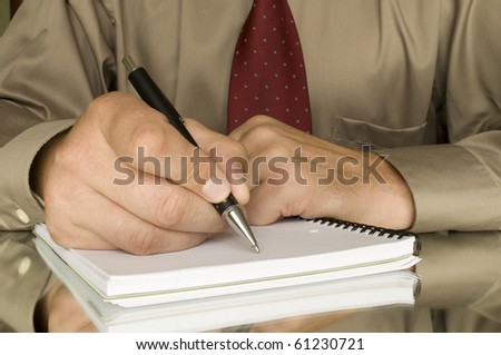 hands with pen writing on the notebook and reflection