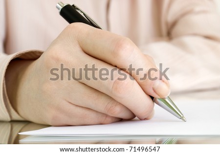 pen in hand writing on the page and reflection
