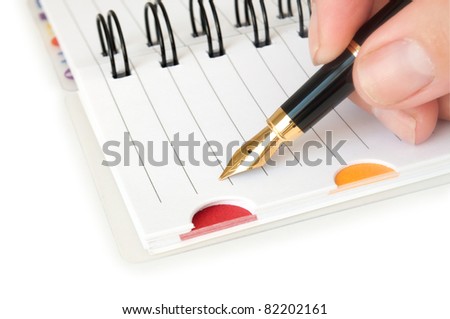hand with pen writing on the notebook