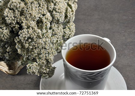 Cup of healing tea and yarrow flowers