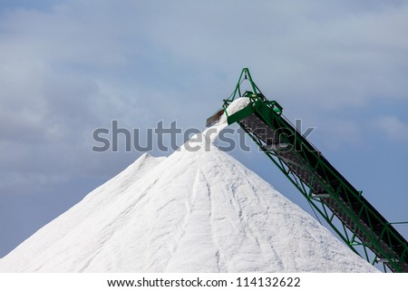 Extraction of salt. Salt mountains on blue sky.